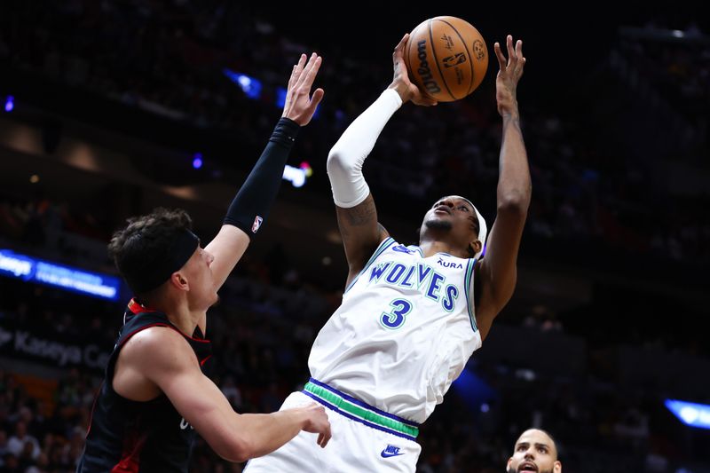 MIAMI, FLORIDA - DECEMBER 18: Jaden McDaniels #3 of the Minnesota Timberwolves shoots the ball over Tyler Herro #14 of the Miami Heat during the first quarter of the game at Kaseya Center on December 18, 2023 in Miami, Florida. NOTE TO USER: User expressly acknowledges and agrees that, by downloading and or using this photograph, User is consenting to the terms and conditions of the Getty Images License Agreement. (Photo by Megan Briggs/Getty Images)