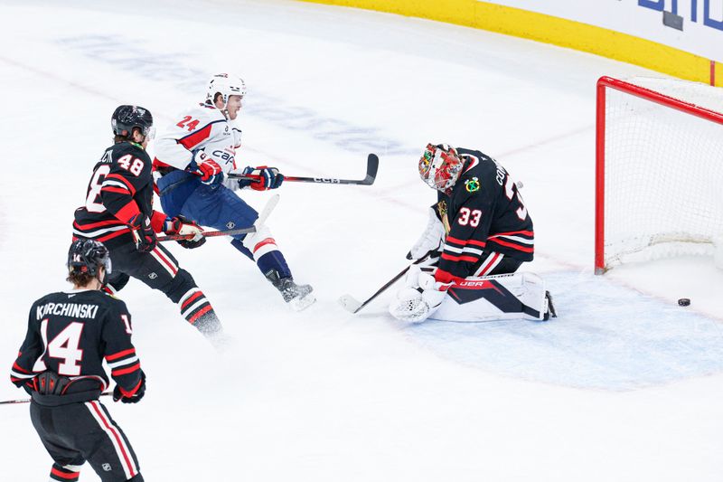Jan 9, 2026; Chicago, Illinois, USA; Washington Capitals center Connor McMichael (24) shoots and scores against Chicago Blackhawks goaltender Drew Commesso (33) during the first period at United Center. Mandatory Credit: Kamil Krzaczynski-Imagn Images