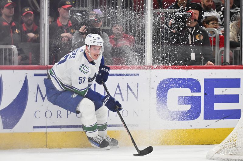 Feb 13, 2024; Chicago, Illinois, USA; Vancouver Canucks defenseman Tyler Myers (57) takes control of the puck behind his net in the first period against the Chicago Blackhawks at United Center. Mandatory Credit: Jamie Sabau-USA TODAY Sports