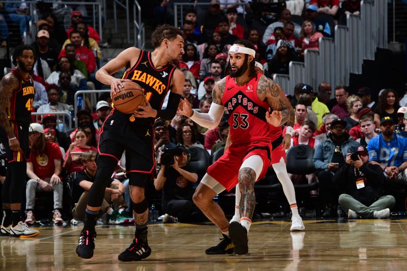 ATLANTA, GA - February 23: Trae Young #11 of the Atlanta Hawks handles the ball during the game as Gary Trent Jr. #33 of the Toronto Raptors plays defense on February 23, 2024 at State Farm Arena in Atlanta, Georgia.  NOTE TO USER: User expressly acknowledges and agrees that, by downloading and/or using this Photograph, user is consenting to the terms and conditions of the Getty Images License Agreement. Mandatory Copyright Notice: Copyright 2024 NBAE (Photo by Scott Cunningham/NBAE via Getty Images)