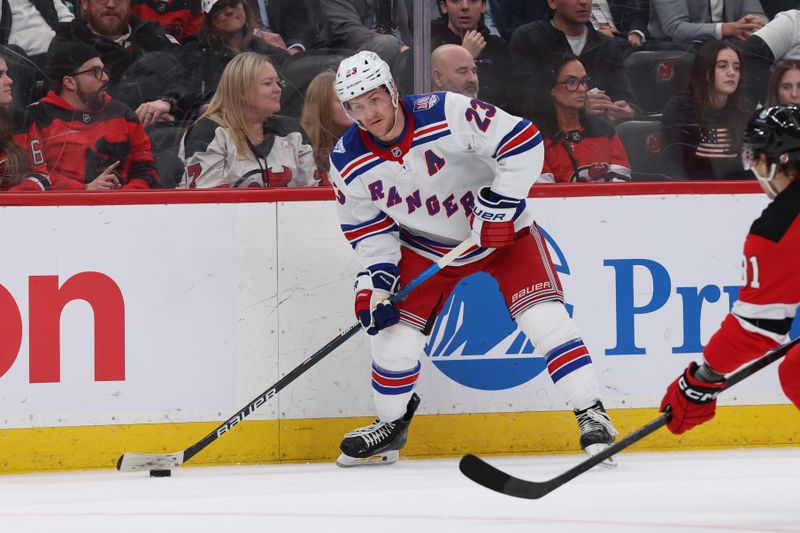 Mar 7, 2026; Newark, New Jersey, USA; New York Rangers defenseman Adam Fox (23) looks to move the puck against the New Jersey Devils during the third period at Prudential Center. Mandatory Credit: Thomas Salus-Imagn Images