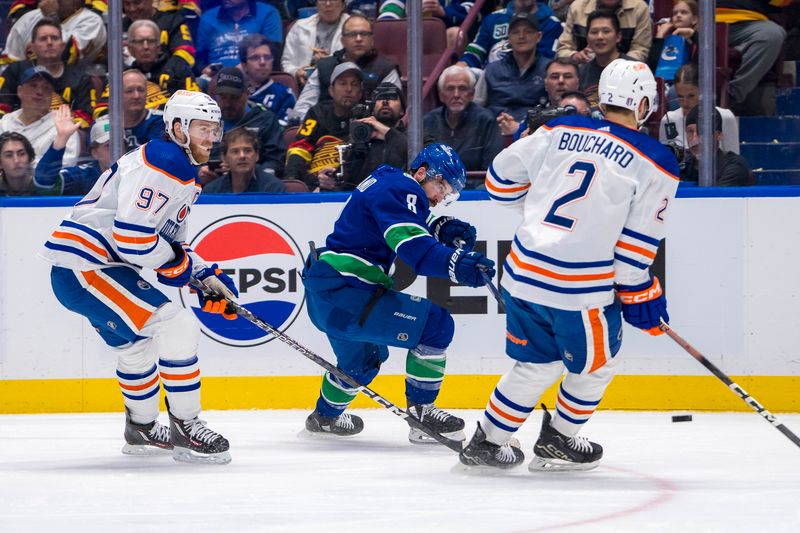 May 8, 2024; Vancouver, British Columbia, CAN; Vancouver Canucks forward Conor Garland (8) shoots around Edmonton Oilers forward Connor McDavid (97) and defenseman Evan Bouchard (2) during the first period in game one of the second round of the 2024 Stanley Cup Playoffs at Rogers Arena. Mandatory Credit: Bob Frid-USA TODAY Sports