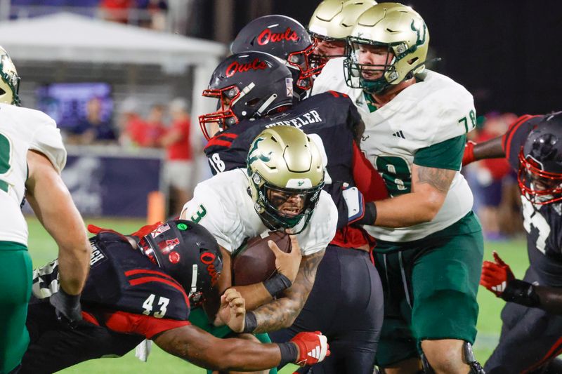 Nov 1, 2024; Boca Raton, Florida, USA;  South Florida Bulls quarterback Bryce Archie (3) dives past Florida Atlantic Owls linebacker Jackson Ambush (43) during the second half at FAU Stadium. Mandatory Credit: Reinhold Matay-Imagn Images