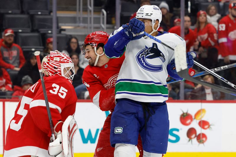 Dec 1, 2024; Detroit, Michigan, USA;  Detroit Red Wings center Dylan Larkin (71) and Vancouver Canucks center Dakota Joshua (81) fight for position in front of goaltender Ville Husso (35) in the third period at Little Caesars Arena. Mandatory Credit: Rick Osentoski-Imagn Images