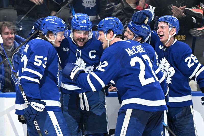 Jan 1, 2026; Toronto, Ontario, CAN;  Toronto Maple Leafs forward Auston Matthews (34) celebrates with forwards Easton Cowan (53) and Nick Robertson (89) and defensemen Jake McCabe (22) and Troy Stecher (28) after scoring his third goal of the game against the Winnipeg Jets in the third period at Scotiabank Arena. Mandatory Credit: Dan Hamilton-Imagn Images