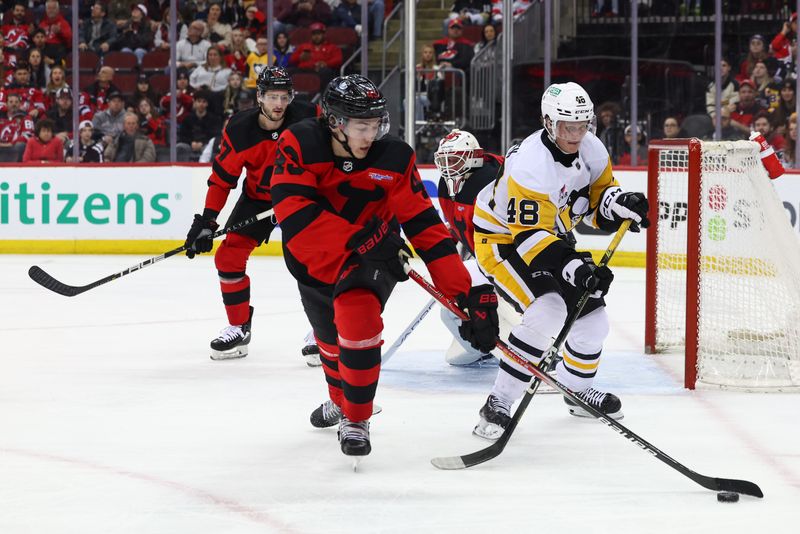 Mar 19, 2024; Newark, New Jersey, USA; New Jersey Devils defenseman Luke Hughes (43) takes the puck away from Pittsburgh Penguins right wing Valtteri Puustinen (48) during the first period at Prudential Center. Mandatory Credit: Ed Mulholland-USA TODAY Sports