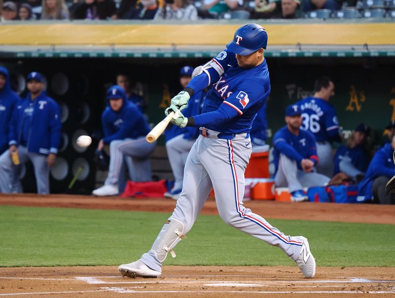 Sep 25, 2024; Oakland, California, USA; Texas Rangers first baseman Nathaniel Lowe (30) hits an RBI single against the Oakland Athletics during the first inning at Oakland-Alameda County Coliseum. Mandatory Credit: Kelley L Cox-Imagn Images