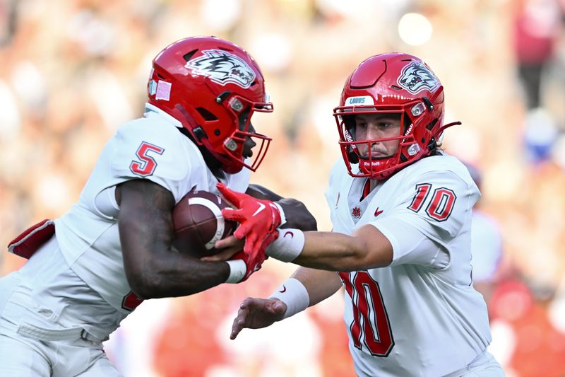 Sep 2, 2023; College Station, Texas, USA; New Mexico Lobos quarterback Dylan Hopkins (10) hands off the battle to New Mexico Lobos running back Jacory Croskey-Merritt (5) during the first quarter against the Texas A&M Aggies at Kyle Field. Mandatory Credit: Maria Lysaker-USA TODAY Sports