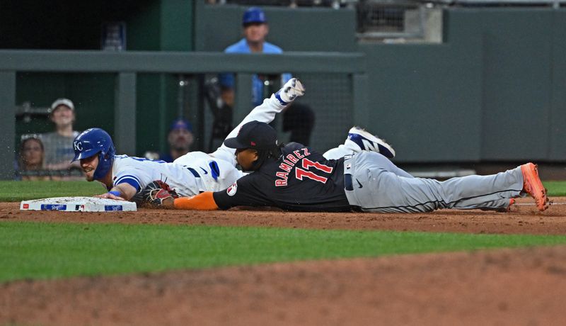 Jun 27, 2024; Kansas City, Missouri, USA;  Kansas City Royals third baseman Nick Loftin (12) dives for third base against Cleveland Guardians third baseman Jose Ramirez (11) in the fifth inning at Kauffman Stadium. Mandatory Credit: Peter Aiken-USA TODAY Sports