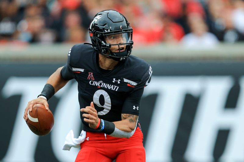 Sep 4, 2021; Cincinnati, Ohio, USA; Cincinnati Bearcats quarterback Desmond Ridder (9) scrambles with the ball against the Miami (Oh) Redhawks in the first half at Nippert Stadium. Mandatory Credit: Aaron Doster-USA TODAY Sports