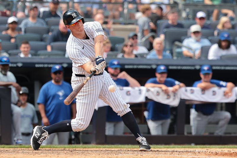 Aug 4, 2024; Bronx, New York, USA;  New York Yankees third baseman DJ LeMahieu (26) hits an RBI sacrifice fly during the sixth inning against the Toronto Blue Jays at Yankee Stadium. Mandatory Credit: Vincent Carchietta-USA TODAY Sports