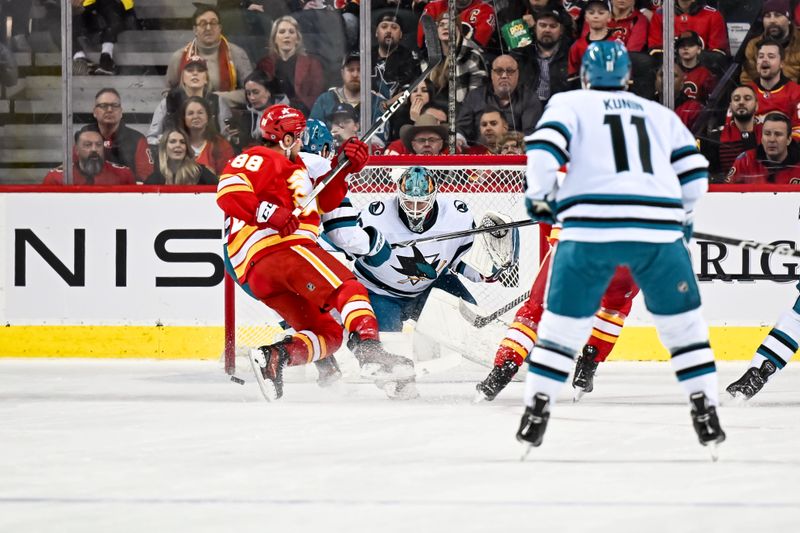 Feb 15, 2024; Calgary, Alberta, CAN; San Jose Sharks goaltender Mackenzie Blackwood (29) keeps his eye on the puck with Calgary Flames left wing Andrew Mangiapane (88) on the attack during the first period at Scotiabank Saddledome. Mandatory Credit: Brett Holmes-USA TODAY Sports