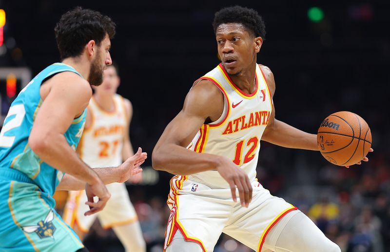 ATLANTA, GEORGIA - MARCH 23:  De'Andre Hunter #12 of the Atlanta Hawks looks to drive against Vasa Micic #22 of the Charlotte Hornets during the first quarter at State Farm Arena on March 23, 2024 in Atlanta, Georgia.  NOTE TO USER: User expressly acknowledges and agrees that, by downloading and/or using this photograph, user is consenting to the terms and conditions of the Getty Images License Agreement.  (Photo by Kevin C. Cox/Getty Images)