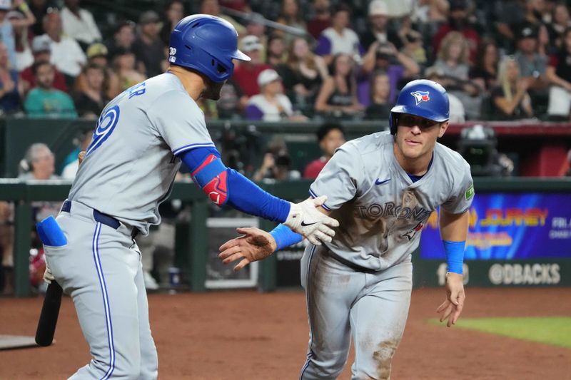 Jul 12, 2024; Phoenix, Arizona, USA; Toronto Blue Jays outfielder Daulton Varsho (25) slaps hands with Toronto Blue Jays outfielder Kevin Kiermaier (39) after scoring a run against the Arizona Diamondbacks during the seventh inning at Chase Field. Mandatory Credit: Joe Camporeale-USA TODAY Sports