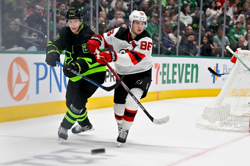 Mar 14, 2024; Dallas, Texas, USA; Dallas Stars defenseman Esa Lindell (23) clears the puck in front of New Jersey Devils center Jack Hughes (86) during the first period at the American Airlines Center. Mandatory Credit: Jerome Miron-USA TODAY Sports