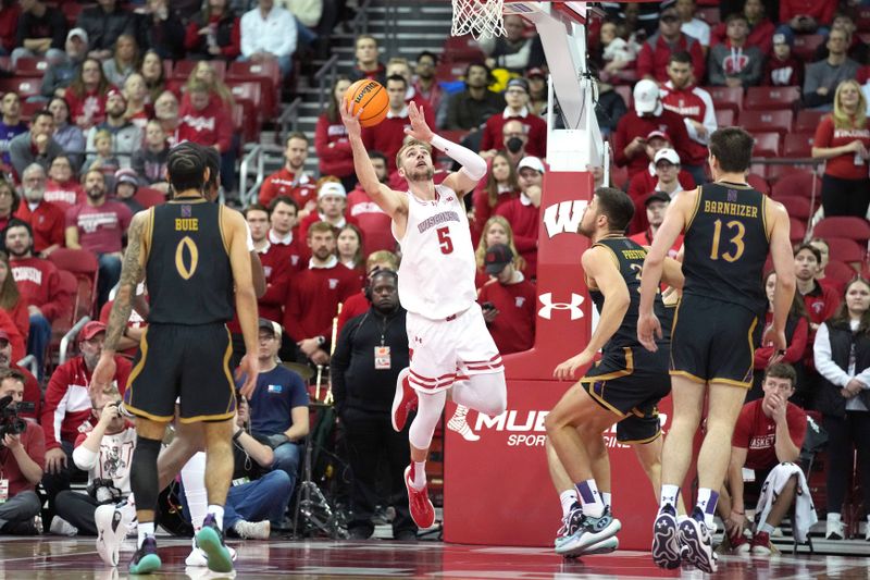 Jan 13, 2024; Madison, Wisconsin, USA; Wisconsin Badgers forward Tyler Wahl (5) scores against Northwestern Wildcats forward Blake Preston (32) during the first half at the Kohl Center. Mandatory Credit: Kayla Wolf-USA TODAY Sports