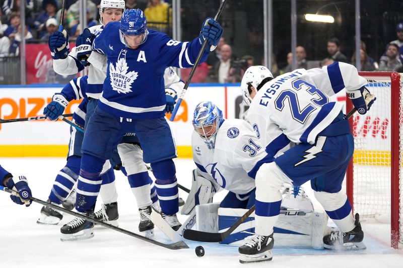 Oct 21, 2024; Toronto, Ontario, CAN; Toronto Maple Leafs forward John Tavares (91), Tampa Bay Lightning forward Michael Eyssimont (23) and goaltender Jonas Johansson (31) battle for a rebound during the third period at Scotiabank Arena. Mandatory Credit: John E. Sokolowski-Imagn Images