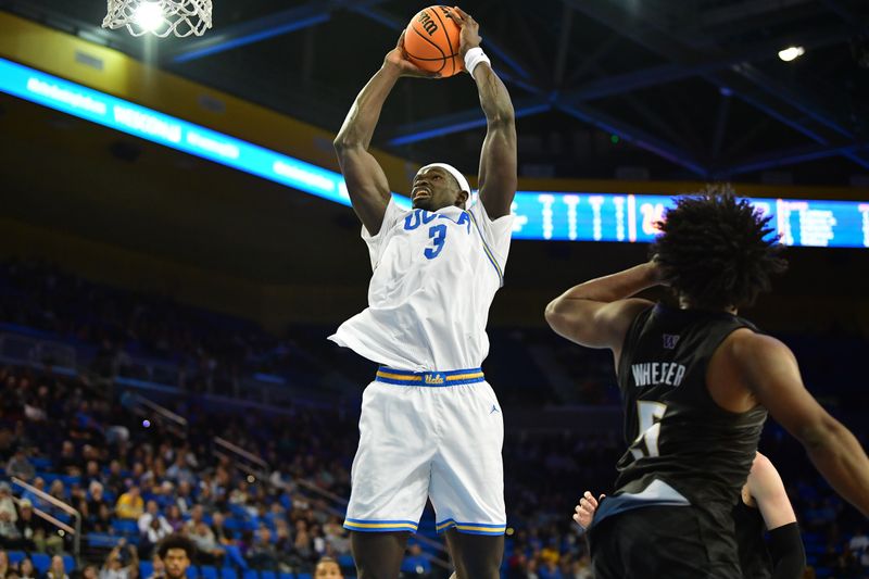 January 14, 2024; Los Angeles, California, USA; UCLA Bruins forward Adem Bona (3) moves to the basket against Washington Huskies guard Sahvir Wheeler (5) during the second half at Pauley Pavilion. Mandatory Credit: Gary A. Vasquez-USA TODAY Sports