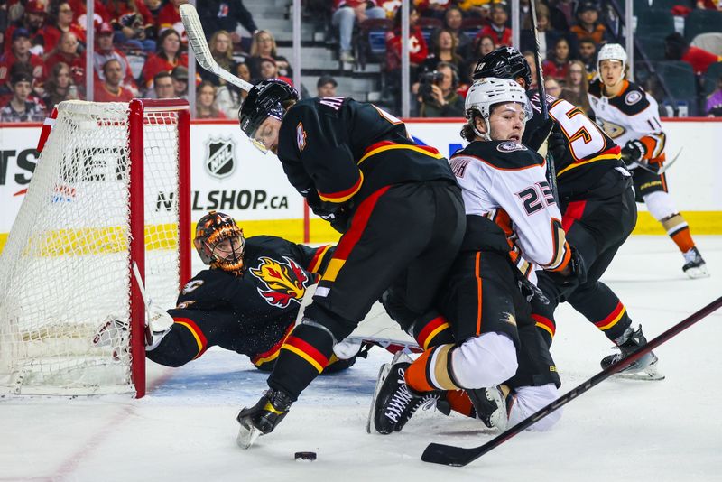 Apr 2, 2024; Calgary, Alberta, CAN; Calgary Flames defenseman Rasmus Andersson (4) and Anaheim Ducks center Mason McTavish (23) battles for the puck in front of Calgary Flames goaltender Jacob Markstrom (25) during the first period at Scotiabank Saddledome. Mandatory Credit: Sergei Belski-USA TODAY Sports