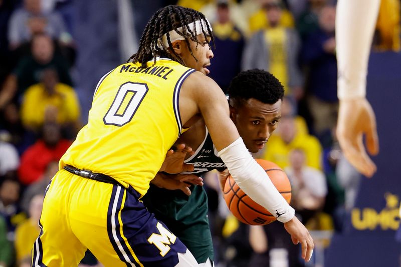 Feb 18, 2023; Ann Arbor, Michigan, USA;  Michigan State Spartans guard Tyson Walker (2) dribbles the ball against Michigan Wolverines guard Dug McDaniel (0) in the second half at Crisler Center. Mandatory Credit: Rick Osentoski-USA TODAY Sports