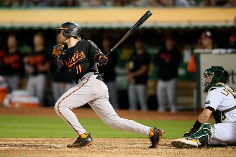 Aug 18, 2023; Oakland, California, USA; Baltimore Orioles infielder Jordan Westburg (11) hits an RBI single against the Oakland Athletics during the fifth inning at Oakland-Alameda County Coliseum. Mandatory Credit: Robert Edwards-USA TODAY Sports