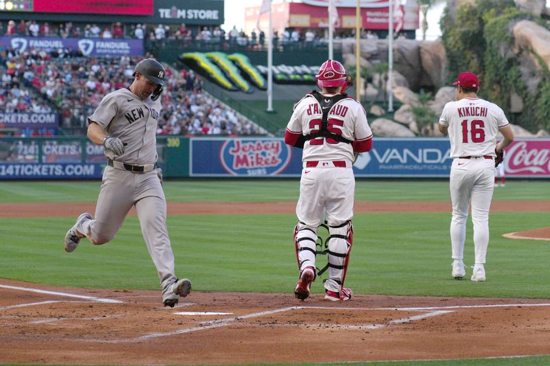 May 28, 2025; Anaheim, California, USA; New York Yankees first baseman Paul Goldschmidt (48) scores on a sacrifice fly ball in the first inning as Los Angeles Angels catcher Travis d'Arnaud (25) and starting pitcher Yusei Kikuchi (16) watch at Angel Stadium. Mandatory Credit: Kirby Lee-Imagn Images