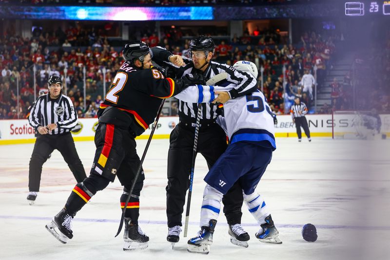 Oct 26, 2024; Calgary, Alberta, CAN; Winnipeg Jets center Mark Scheifele (55) and Calgary Flames defenseman MacKenzie Weegar (52) fights during the third period at Scotiabank Saddledome. Mandatory Credit: Sergei Belski-Imagn Images