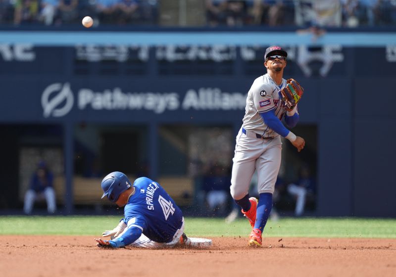 Sep 11, 2024; Toronto, Ontario, CAN; Toronto Blue Jays designated hitter George Springer (4) is tagged out at second base by New York Mets shortstop Francisco Lindor (12) during the first inning at Rogers Centre. Mandatory Credit: Nick Turchiaro-Imagn Images