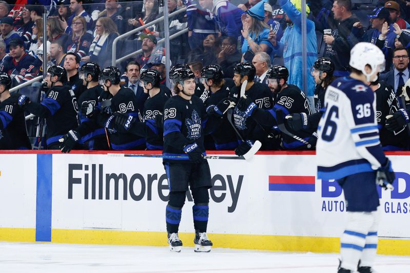 Oct 28, 2024; Winnipeg, Manitoba, CAN;  Toronto Maple Leafs forward Matthew Knies (23) is congratulated by his teammates on his goal against the Winnipeg Jets during the second period at Canada Life Centre. Mandatory Credit: Terrence Lee-Imagn Images