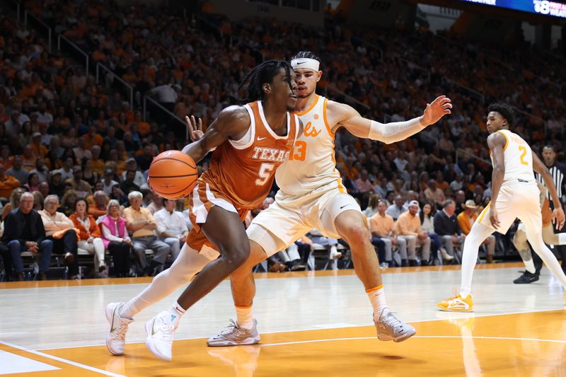 Jan 28, 2023; Knoxville, Tennessee, USA; Texas Longhorns guard Marcus Carr (5) moves the ball against Tennessee Volunteers forward Olivier Nkamhoua (13) during the second half at Thompson-Boling Arena. Mandatory Credit: Randy Sartin-USA TODAY Sports