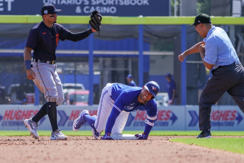 Feb 28, 2023; Dunedin, Florida, USA; Toronto Blue Jays center fielder George Springer (4) is tagged out by Detroit Tigers second baseman Cesar Hernandez (15) during the third inning at TD Ballpark. Mandatory Credit: Mike Watters-USA TODAY Sports