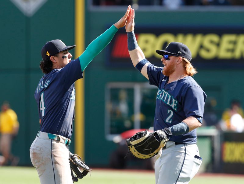 Aug 18, 2024; Pittsburgh, Pennsylvania, USA;  Seattle Mariners third baseman Josh Rojas (4) and first baseman Justin Turner (2) high-five after defeating the Pittsburgh Pirates at PNC Park. Seattle won 10-3. Mandatory Credit: Charles LeClaire-USA TODAY Sports