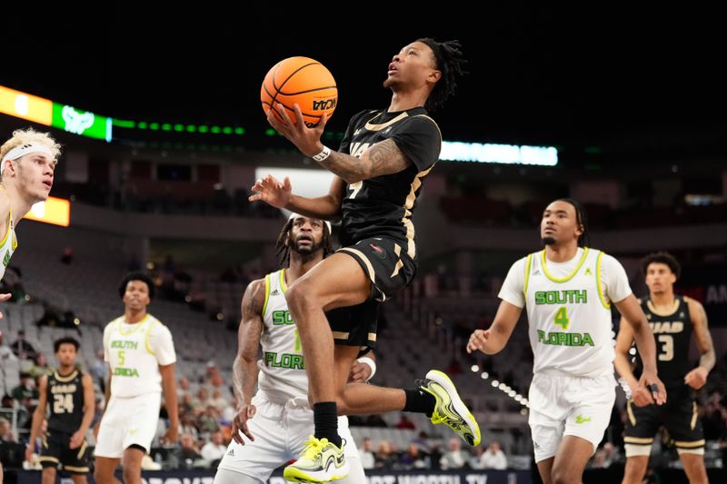 Mar 16, 2024; Fort Worth, TX, USA;  UAB Blazers guard Eric Gaines (4) drives to the basket for a layup past South Florida Bulls guard Selton Miguel (1) during the second half at Dickies Arena. Mandatory Credit: Chris Jones-USA TODAY Sports