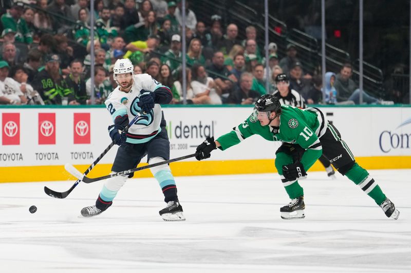 Oct 13, 2024; Dallas, Texas, USA;  Seattle Kraken right wing Oliver Bjorkstrand (22) passes the puck against Dallas Stars center Oskar Bäck (10) during the first period at American Airlines Center. Mandatory Credit: Chris Jones-Imagn Images