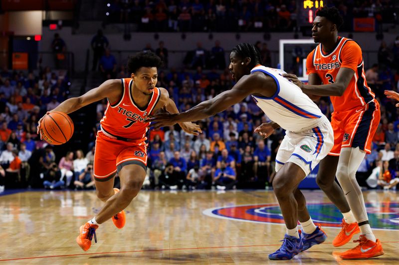 Jan 24, 2026; Gainesville, Florida, USA; Auburn Tigers guard Keyshawn Hall (7) drives to the basket past Florida Gators center Rueben Chinyelu (9) during the first half at Exactech Arena at the Stephen C. O'Connell Center. Mandatory Credit: Matt Pendleton-Imagn Images