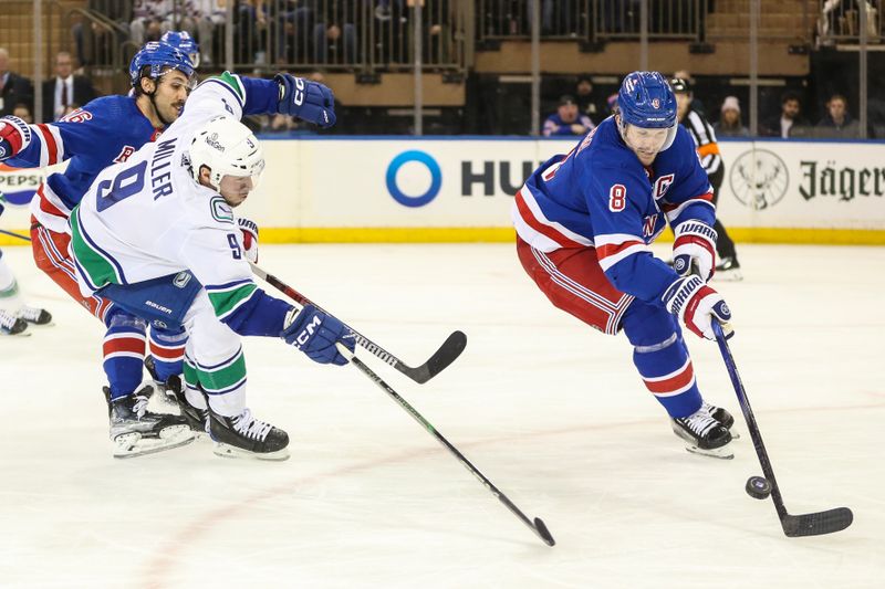 Jan 8, 2024; New York, New York, USA;  Vancouver Canucks center J.T. Miller (9) and New York Rangers defenseman Jacob Trouba (8) chases the puck in the second period at Madison Square Garden. Mandatory Credit: Wendell Cruz-USA TODAY Sports