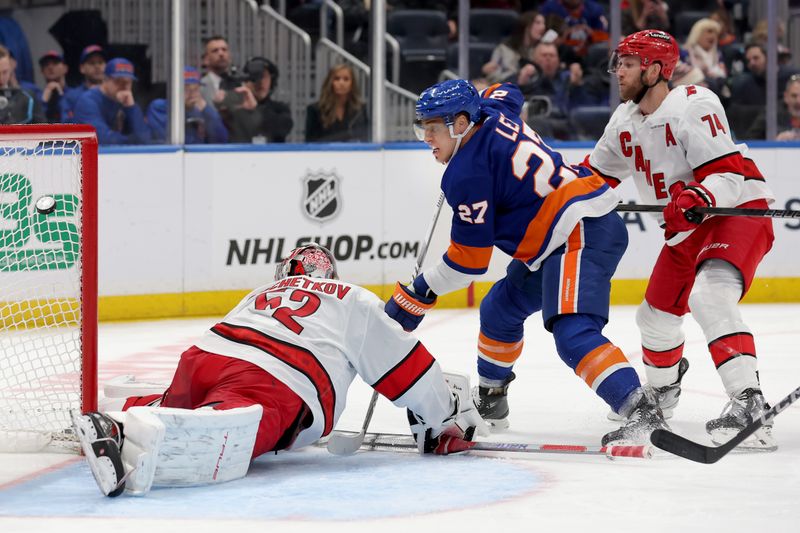 Jan 25, 2025; Elmont, New York, USA; New York Islanders left wing Anders Lee (27) scores the game tying goal against Carolina Hurricanes goaltender Pyotr Kochetkov (52) and defenseman Jaccob Slavin (74) during the third period at UBS Arena. Mandatory Credit: Brad Penner-Imagn Images