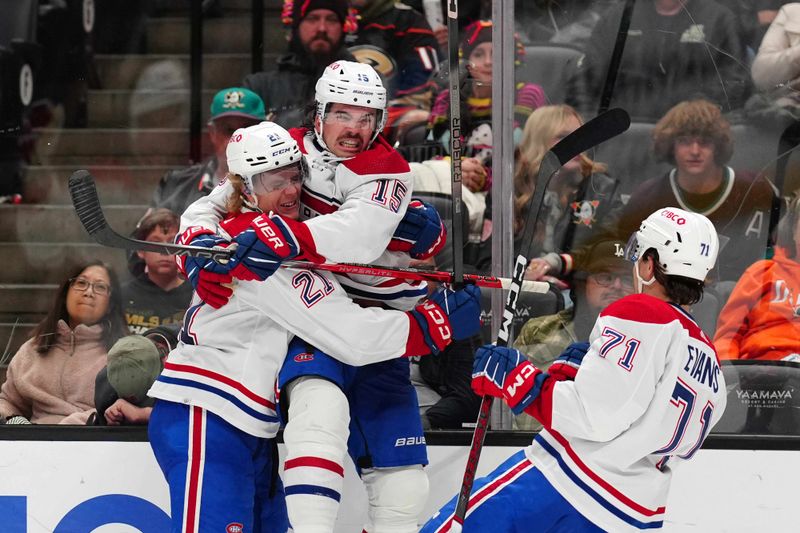 Nov 22, 2023; Anaheim, California, USA; Montreal Canadiens center Alex Newhook (15) celebrates with defenseman Kaiden Guhle (21) and center Jake Evans (71) after scoring a goal against the Anaheim Ducks in the third period at Honda Center. Mandatory Credit: Kirby Lee-USA TODAY Sports