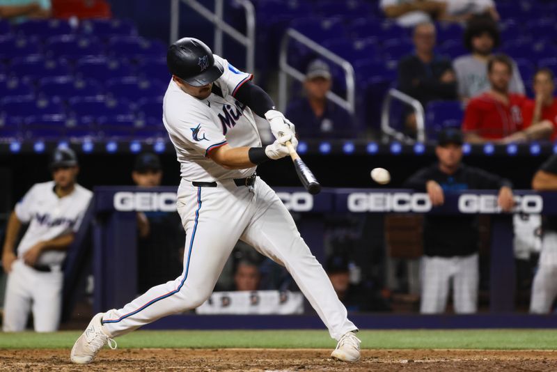 Sep 4, 2024; Miami, Florida, USA; Miami Marlins first baseman Jake Burger (36) hits an RBI single against the Washington Nationals during the eighth inning at loanDepot Park. Mandatory Credit: Sam Navarro-Imagn Images