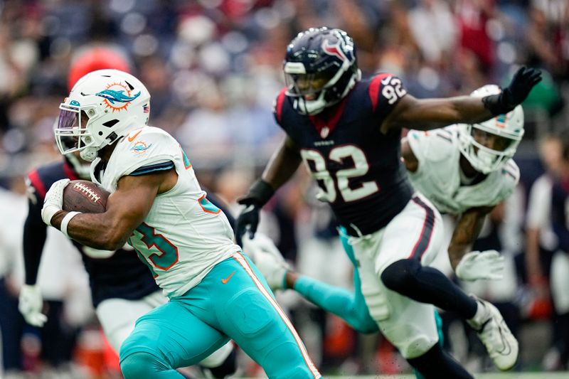 Miami Dolphins running back Chris Brooks, left, runs with the ball as Houston Texans defensive end Dylan Horton (92) tries to stop him during the second half of an NFL preseason football game, Saturday, Aug. 19, 2023, in Houston. (AP Photo/Eric Gay)