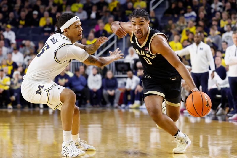 Feb 11, 2025; Ann Arbor, Michigan, USA;  Purdue Boilermakers guard C.J. Cox (0) dribbles defended by Michigan Wolverines guard Rubin Jones (15) in the second half at Crisler Center. Mandatory Credit: Rick Osentoski-Imagn Images