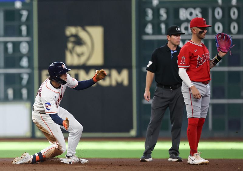 Mar 26, 2026; Houston, Texas, USA; Houston Astros left fielder Joey Loperfido (10) hits a double against the Los Angeles Angels shortstop Zach Neto (9) in the sixth inning at Daikin Park. Mandatory Credit: Thomas Shea-Imagn Images