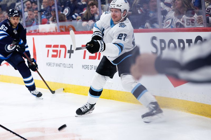 Jan 24, 2025; Winnipeg, Manitoba, CAN; Utah Hockey Club forward Barrett Hayton (27) makes a pass against the Winnipeg Jets during the second period at Canada Life Centre. Mandatory Credit: Terrence Lee-Imagn Images