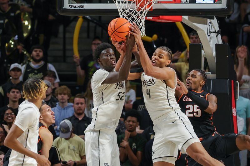 Mar 5, 2025; Orlando, Florida, USA; UCF Knights center Moustapha Thiam (52) and guard Keyshawn Hall (4) jump for the rebound during the second half at Addition Financial Arena. Mandatory Credit: Mike Watters-Imagn Images