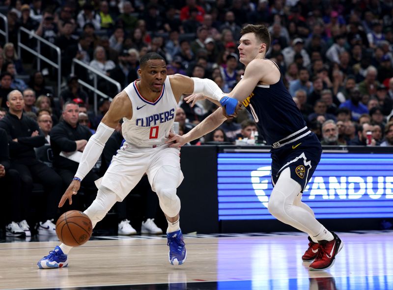 LOS ANGELES, CALIFORNIA - APRIL 04: Russell Westbrook #0 of the LA Clippers drives to the basket on Christian Braun #0 of the Denver Nuggets during the first half at Crypto.com Arena on April 04, 2024 in Los Angeles, California. User is consenting to the terms and conditions of the Getty Images License Agreement. (Photo by Harry How/Getty Images)