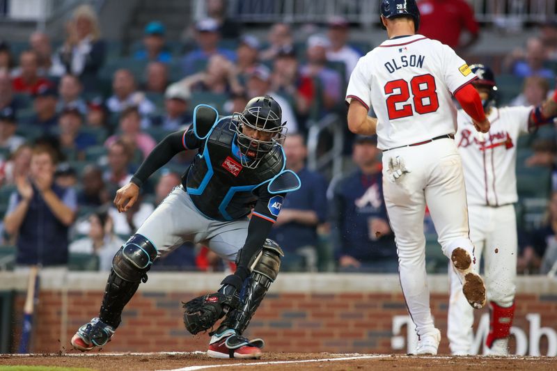 Apr 24, 2024; Atlanta, Georgia, USA; Atlanta Braves first baseman Matt Olson (28) scores past Miami Marlins catcher Christian Bethancourt (25) in the third inning at Truist Park. Mandatory Credit: Brett Davis-USA TODAY Sports
