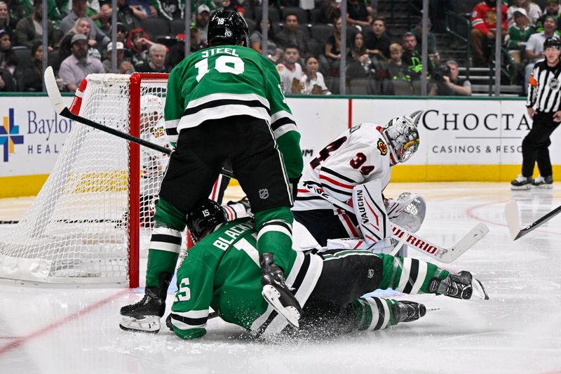 Oct 26, 2024; Dallas, Texas, USA; Dallas Stars center Colin Blackwell (15) and center Sam Steel (18) slide on the ice by Chicago Blackhawks goaltender Petr Mrazek (34) during the second period at the American Airlines Center. Mandatory Credit: Jerome Miron-Imagn Images