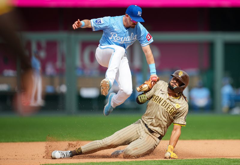 Jun 1, 2024; Kansas City, Missouri, USA; Kansas City Royals second baseman Nick Loftin (12) leaps over San Diego Padres right fielder Fernando Tatis Jr. (23) as he makes the tag during the seventh inning at Kauffman Stadium. Mandatory Credit: Jay Biggerstaff-USA TODAY Sports