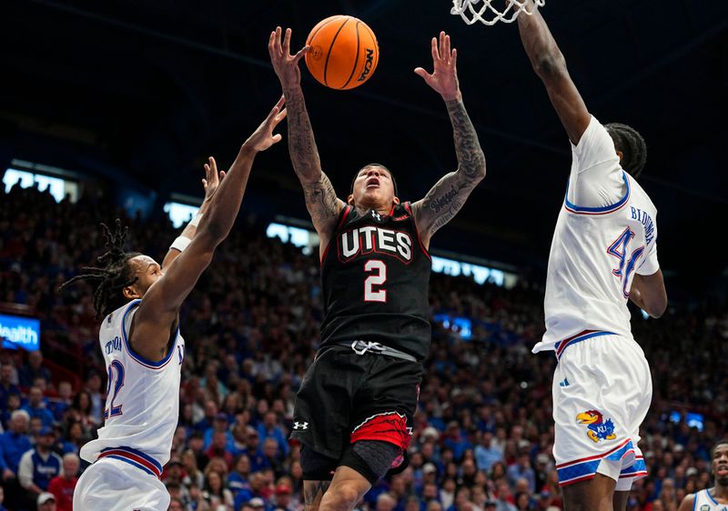 Feb 7, 2026; Lawrence, Kansas, USA; Kansas Jayhawks guard Corbin Allen (2) loses control of the ball while shooting against Kansas Jayhawks guard Darryn Peterson (22) and forward Flory Bidunga (40) during the first half at Allen Fieldhouse. Mandatory Credit: Jay Biggerstaff-Imagn Images