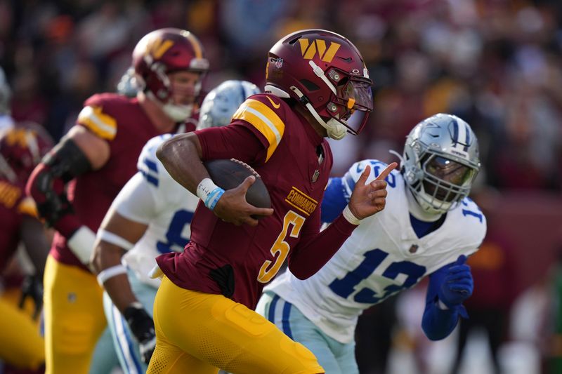 Washington Commanders quarterback Jayden Daniels (5) runs with the football during the first half of an NFL football game against the Dallas Cowboys, Sunday, Nov. 24, 2024, in Landover, Md. (AP Photo/Stephanie Scarbrough)